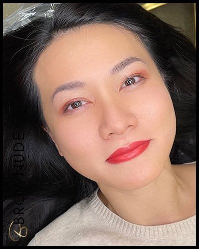 Close-up of woman with enhanced lips after lip blush tattoo procedure.