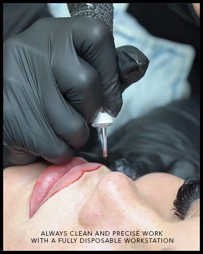 Close-up of a professional performing permanent makeup on a client's lips.