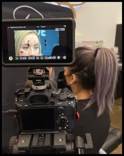 Beauty professional recording a client for permanent makeup procedure.