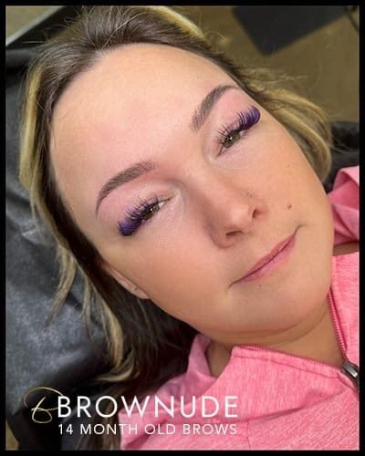 Close-up of woman with newly shaped 14-month-old eyebrows and purple eyelash extensions.