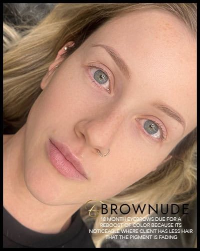 Close-up of a woman with freshly touched-up eyebrows for eyebrow tattoo touch-up timing.